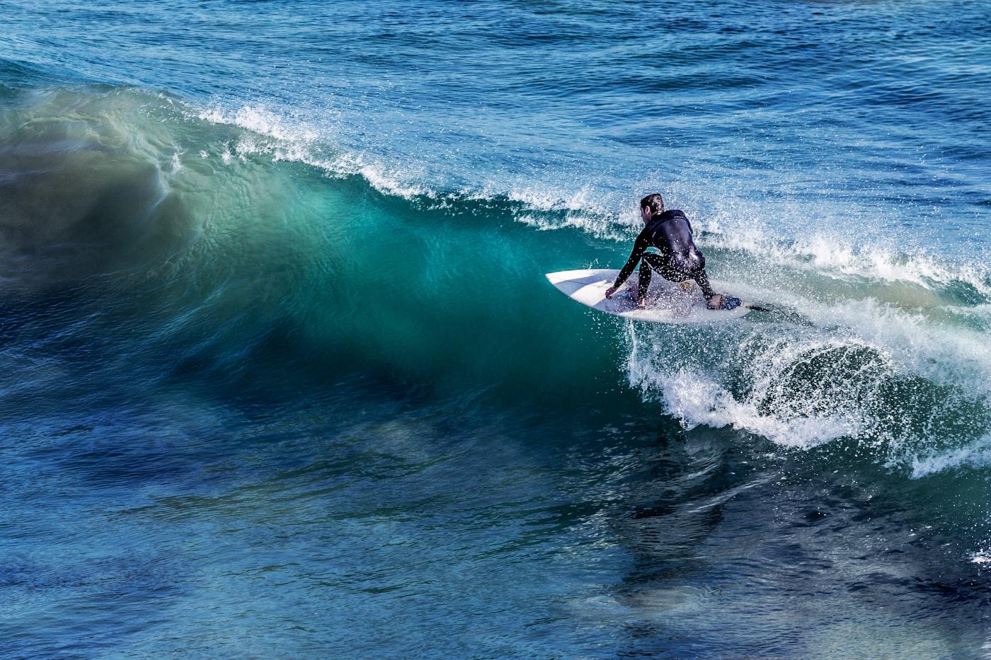 Surfer riding a long left-hand wave on a tropical reef break in Rote Island